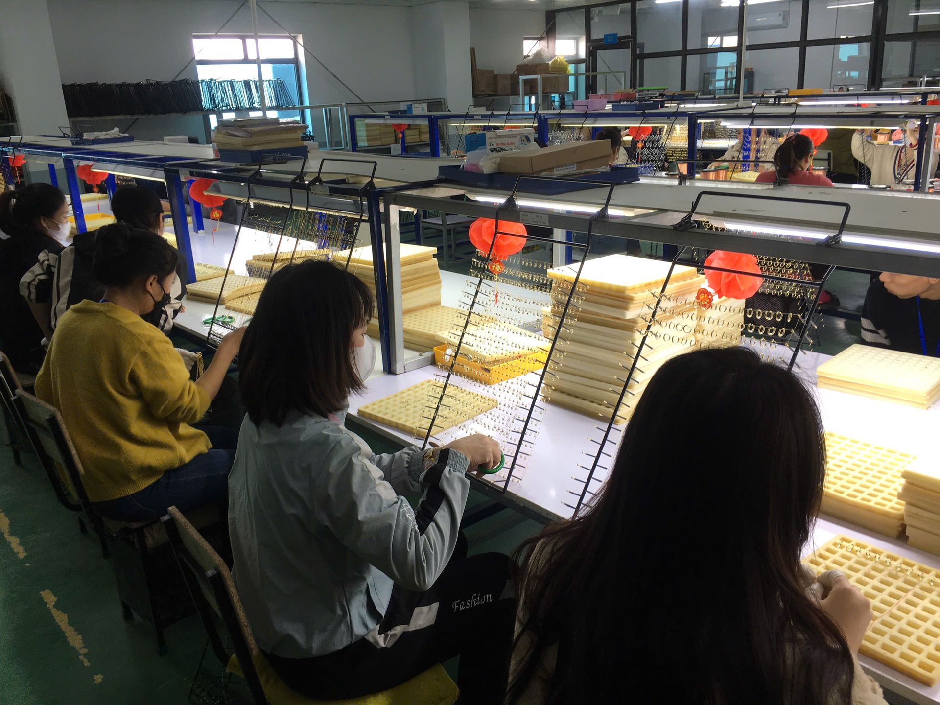 Jinyi Jewelry Factory Vietnam: Artisans at Work in Modern Production Facility | Jewelry Manufacturing Inside the modern Jinyi jewelry factory in Vietnam, skilled artisans engage in detailed jewelry production, hand-polishing custom pieces at specialized workstations.