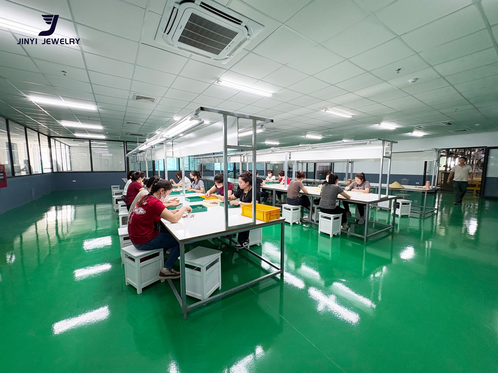 Jinyi Jewelry Factory Vietnam: Artisans at Work in Modern Production Facility | Jewelry Manufacturing Inside the modern Jinyi jewelry factory in Vietnam, skilled artisans engage in detailed jewelry production, hand-polishing custom pieces at specialized workstations.